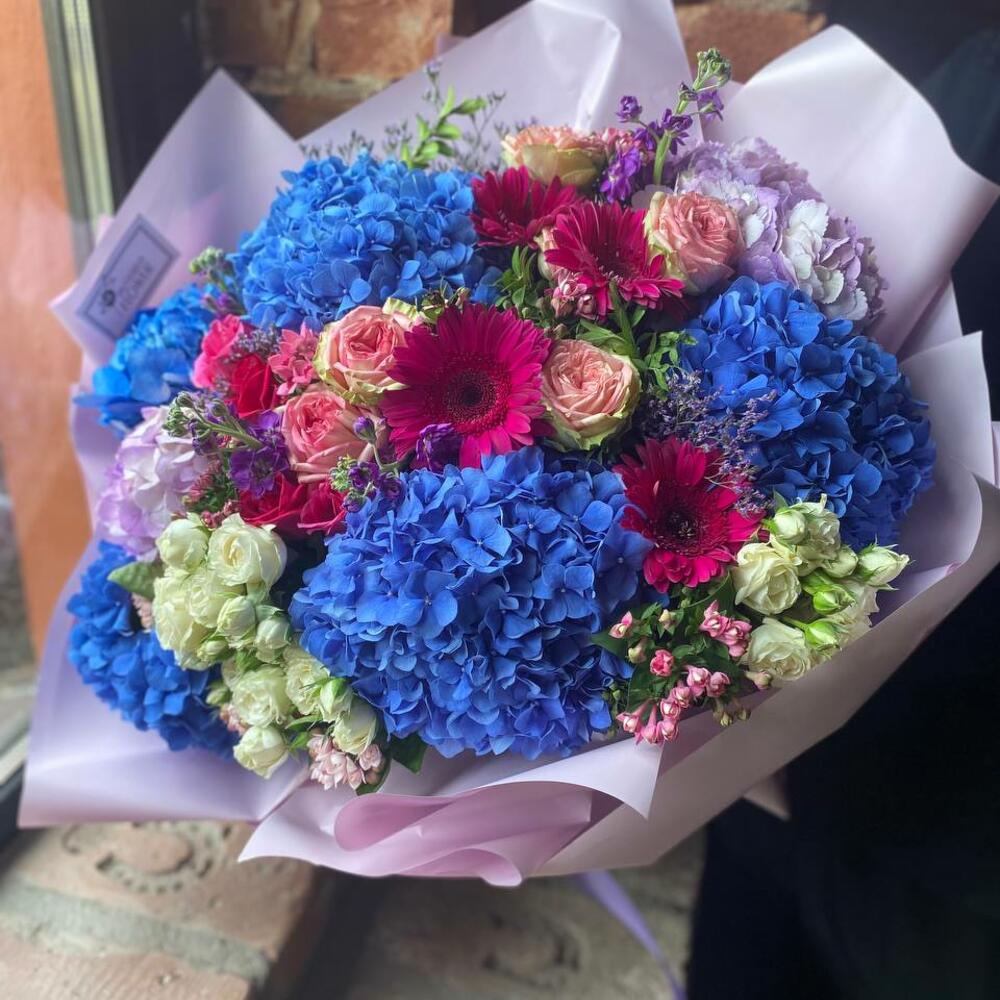 Букет из гортензии, кустовых роз, бовардии, лимониума, гербер и маттиолы в стильной упаковке 